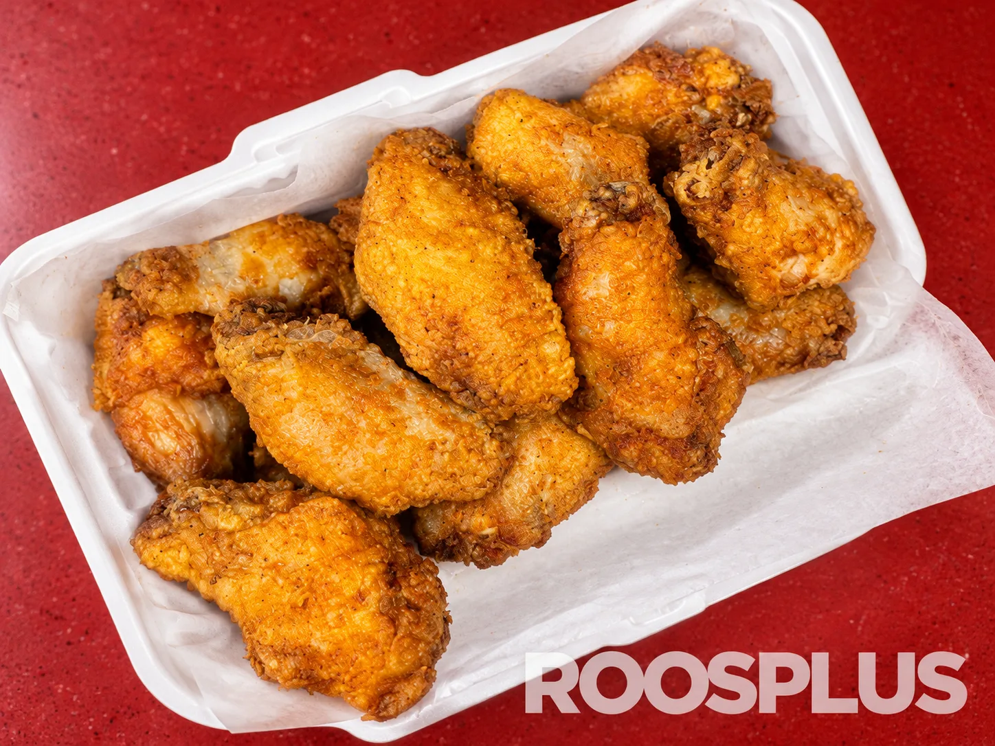 Golden chicken wings in a white takeaway tray lined with paper at Bismillah Pizza, Eglinton Avenue East, Scarborough.