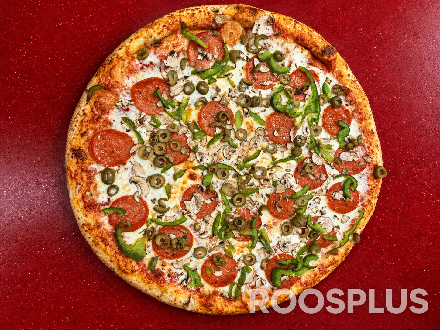 Overhead view of pizza topped with salami, green peppers, mushrooms and green olives at Bismillah Pizza, Eglinton Avenue East, Scarborough.