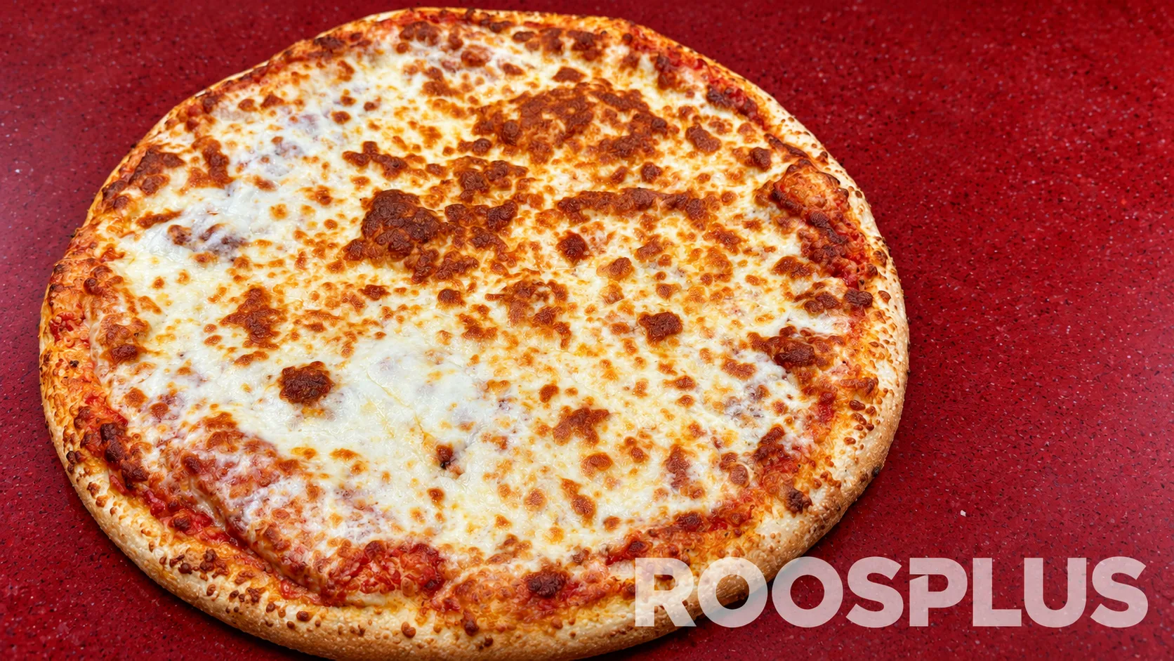 Cheese pizza with a golden crust and browned mozzarella across the surface at Bismillah Pizza, Eglinton Avenue East, Scarborough.