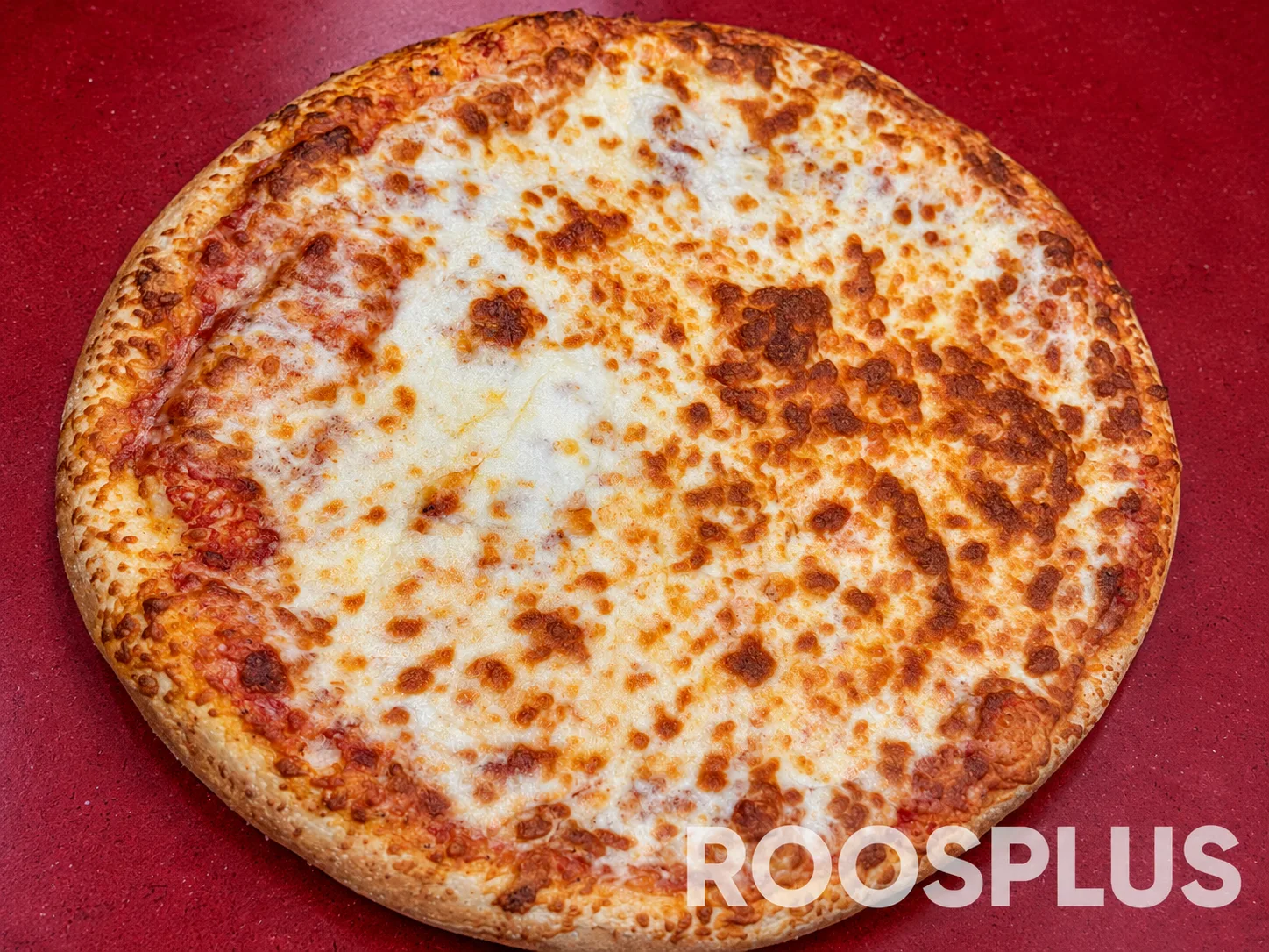 Overhead view of a pizza covered with melted and browned cheese at Bismillah Pizza, Eglinton Avenue East, Scarborough.