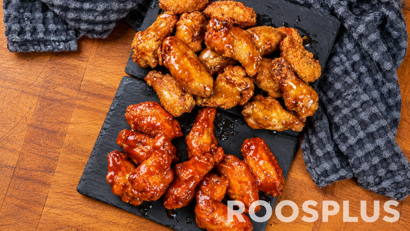 Two portions of chicken wings with amber and red-brown glazes on dark serving boards at Bismillah Pizza, Eglinton Avenue East, Scarborough.