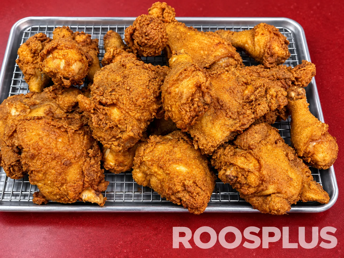 Crispy fried chicken pieces arranged on a metal tray and wire rack at Bismillah Pizza, Eglinton Avenue East, Scarborough.